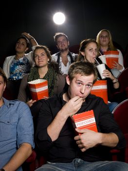 Young man at the movie theater with bag of popcorn