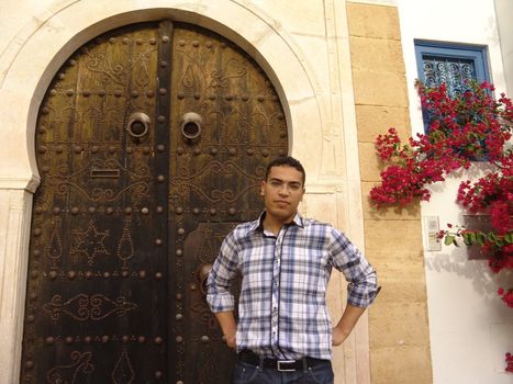 Man standing infront of the famous doors of Sidi Bou Said in Tunis, the capital of Tunisia.