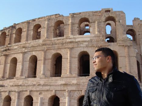 Tunisian man standing in front of El Jem amphitheatre in Tunisia