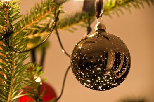 Christmas ball hanging from Christmas tee with great reflection
