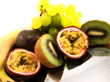 Assorted fruits, isolated on a silver plate, towards white background