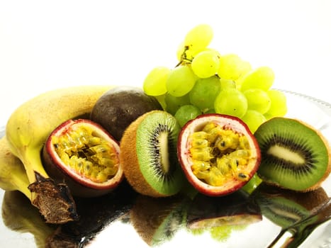 Assorted fruits, isolated on a silver plate, towards white background