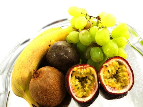 Assorted fruits, isolated on a silver plate, towards white background