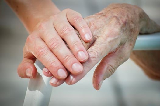 Young and old hand on a backrest