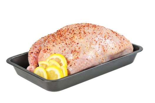 Stuffed chicken  on a baking sheet, decorated with lemon.  Isolated  on white.