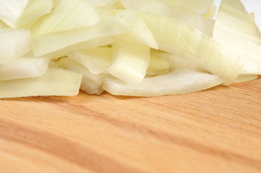 Chopped onions on a wooden board. Isolated on white. Shallow depth of field
