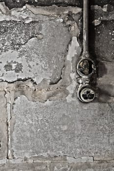 An old electrical wall switch on a wall with flaking plaster