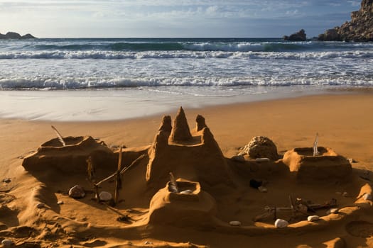 Partly eroded sandcastle with Ghajn Tuffieha Bay in the background