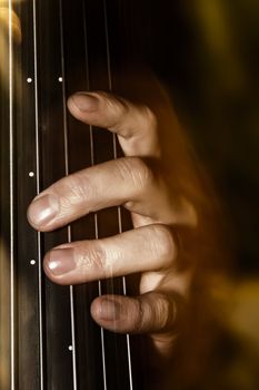 Detail shot of a bassist's fingers on an upright bass fretless neck