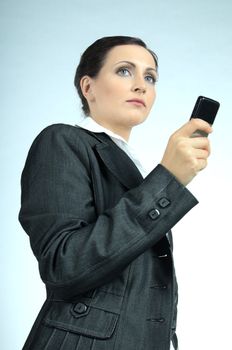 Young business woman, concentrated looking forward, holding a business model cell phone .