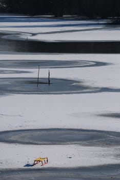 Small frozen river with sledge on snow and ice