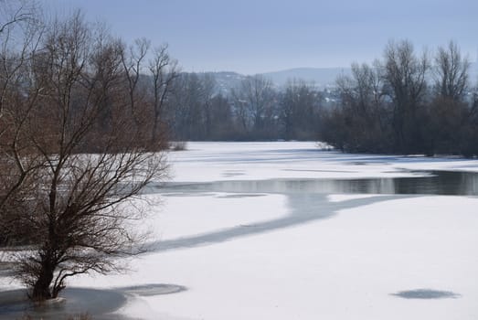 Winter landscape with a small frozen river