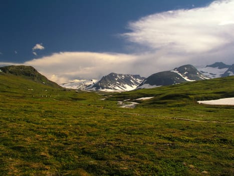 Wild ladscape of snow mountain and meadow