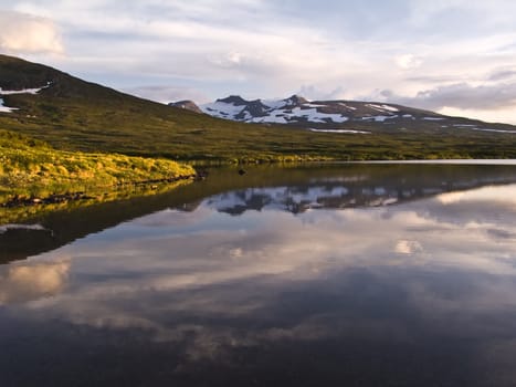 Wild landscape of Lake, reflection of clouds and snow mountains 