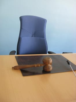 Old wooden gavel,blue chair and court desk