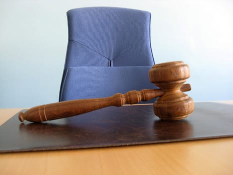 Old wooden gavel ,blue chair and court desk