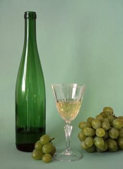 white wine and grapes isolated on green background