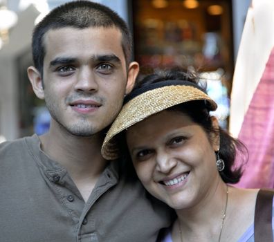 portrait and square format of happy mother wearing a peaked cap close to bright eyed teenage son woth crop space