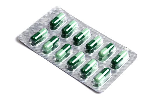 Package of green capsules isolated on white background 
