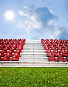 Red bleachers with green field and sky background