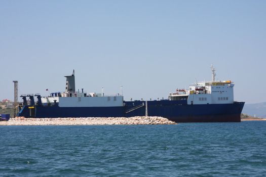 Cargo Ship loading and unloading in the harbour at Cesme, Turkey