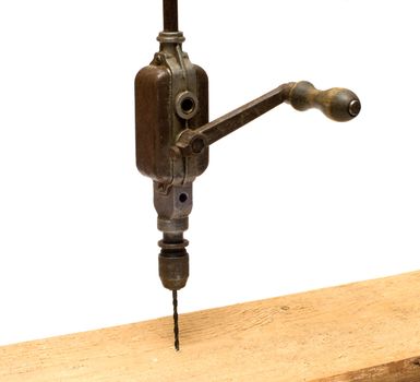 Old hand brace drill the board on a white background.