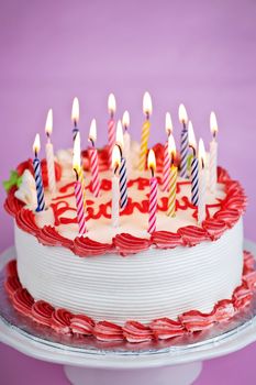 Birthday cake with lit candles and white icing