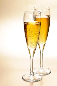 Two full champagne flutes with sparkling wine