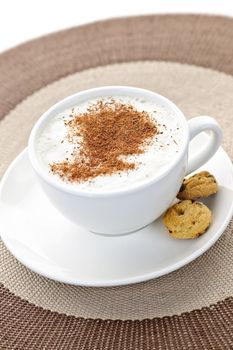 Cappuccino or latte coffee in cup with frothed milk and cookies