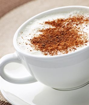 Cappuccino or latte coffee in cup with frothed milk and cookies