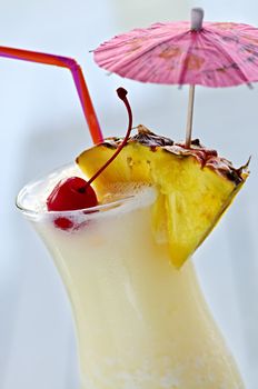 Pina colada drink in hurricane cocktail glass isolated on white background