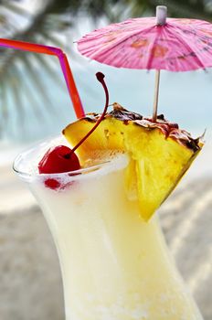 Pina colada tropical drink at sandy beach on the ocean