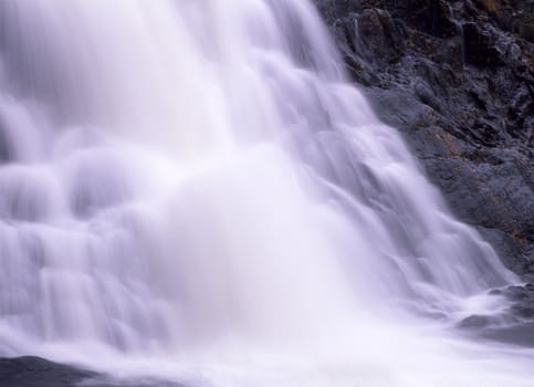 Flowing water from mountain waterfall 
