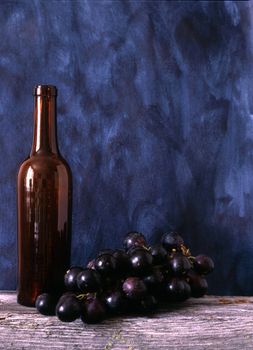 Wine bottle and grapes isolated on painted background