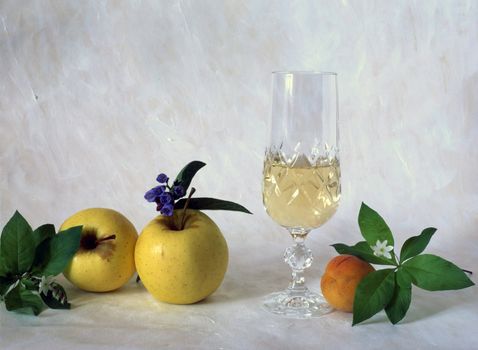A glass of white wine with fruits isolated on painted background