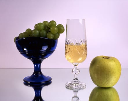 A glass of wine with fruits isolated on mirror
