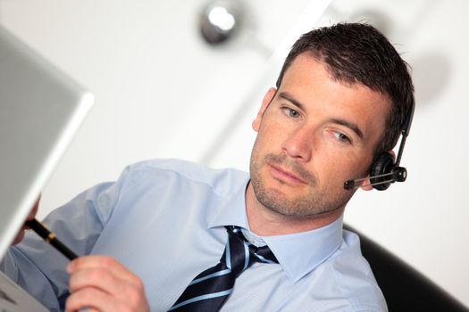 man working with headset and computer in office