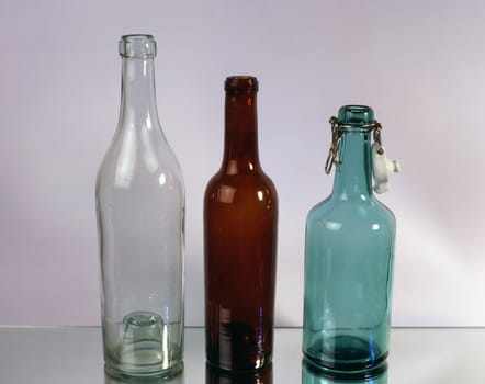 Three old empty bottles isolated on mirror