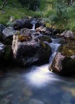 Beautiful mountain stream with mossy rocks 
