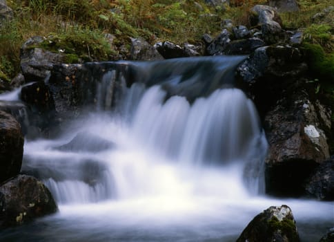 Flowing water of mountain waterfall