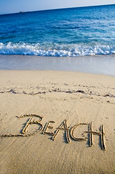 Text Beach written on the sand with wave