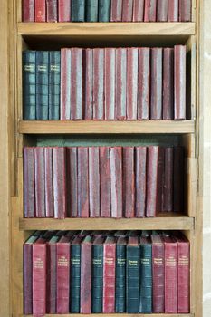 a shelf stacked with leather bound prayer books