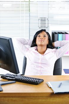 Young black business woman resting at desk in office