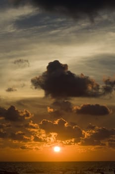 Sunset over ocean with dramatic clouds