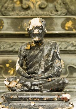 Old, weathered buddhist monk statue in Bangkok, Thailand