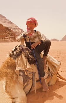 A Bedouin boy relaxing on his camel in Wadi Rum, Jordan