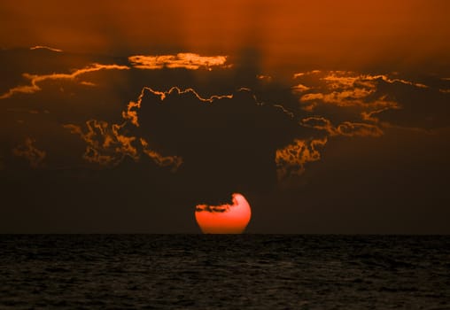 Sunset over ocean with dramatic clouds