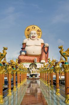 Fat laughing Buddha over blue sky, Koh Samui. Thailand