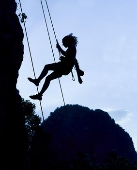 Silhouette of climbing woman in Railey, Thailand