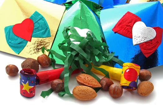 Mixed nuts with party blowers and hats on a plain white background.